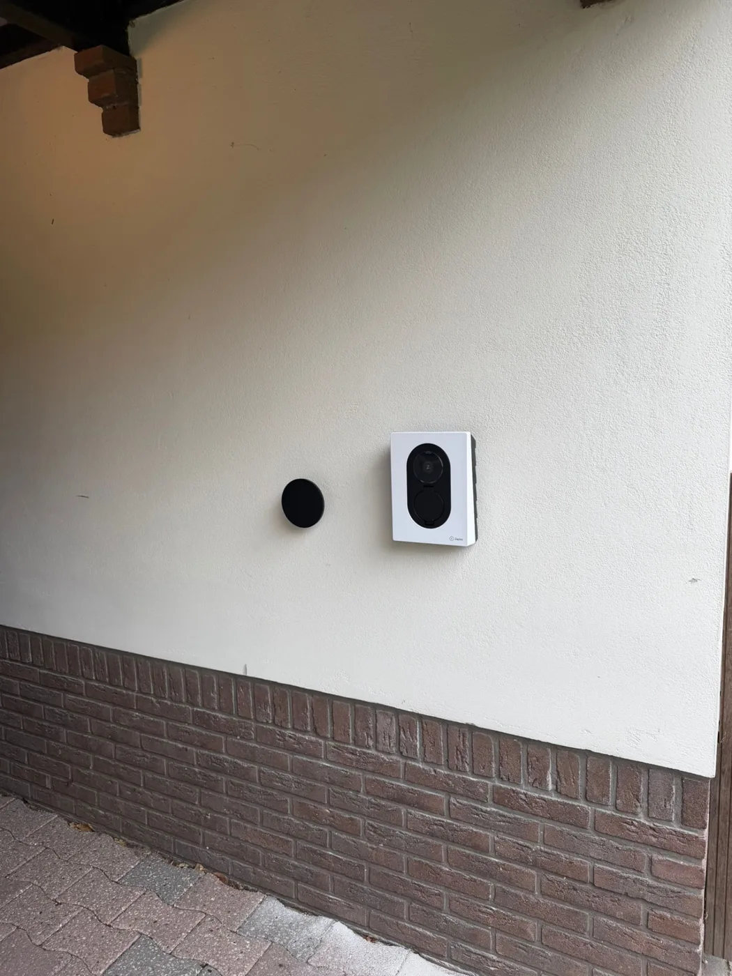 Zaptec Go 2 laadstation met witte cover tegen de lichte gevel van het bijgebouw in Emmen