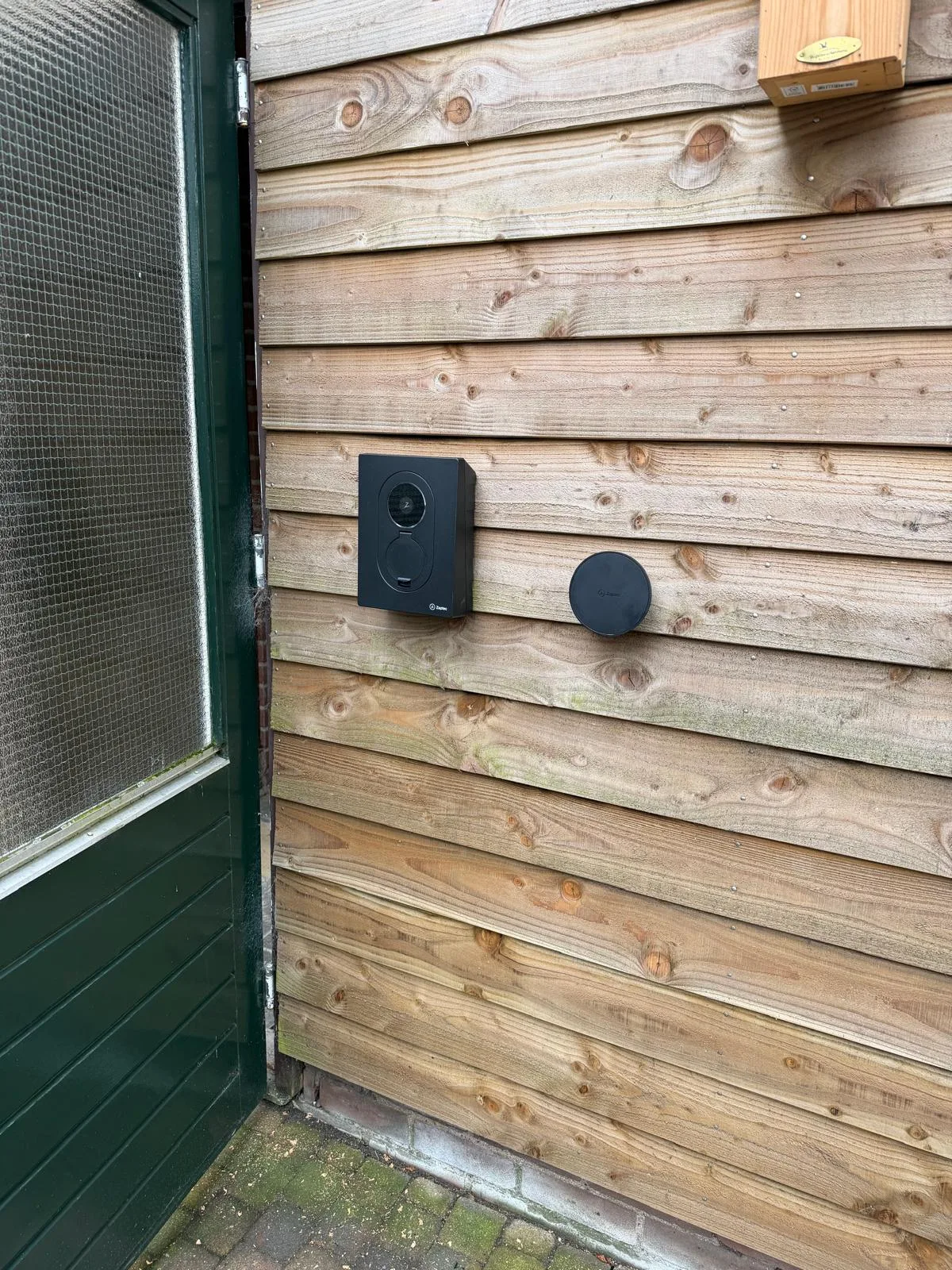 Zaptec Go 2 laadstation met kabelhouder tegen de houten gevel van de schuur in Hoogeveen